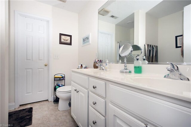 bathroom featuring toilet, vanity, and tile patterned flooring