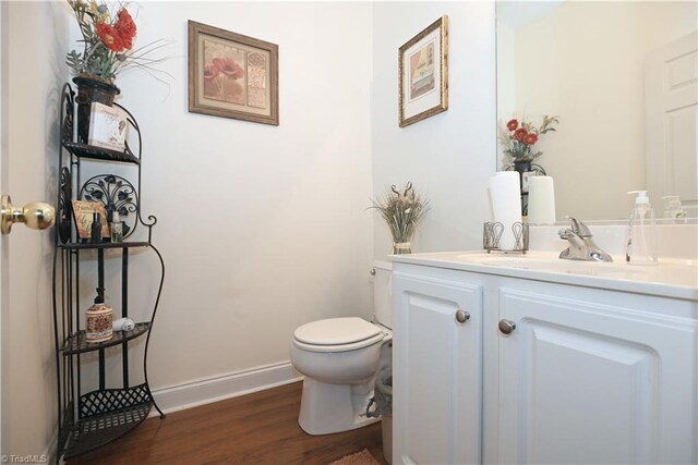 bathroom with hardwood / wood-style floors, vanity, and toilet