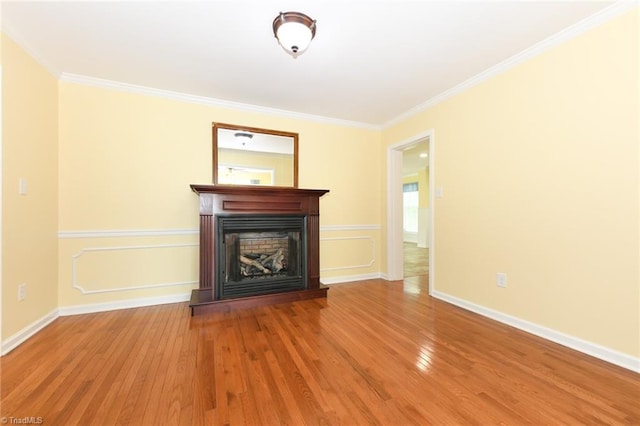2377 Barber Rd, Elon, NC 27244 - unfurnished living room with wood finished floors, crown molding, a fireplace with raised hearth, and baseboards