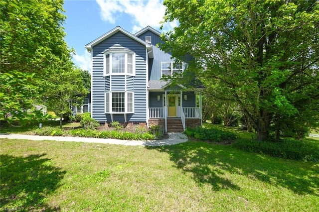 2377 Barber Rd, Elon, NC 27244 - traditional home with covered porch, a front yard, and board and batten siding