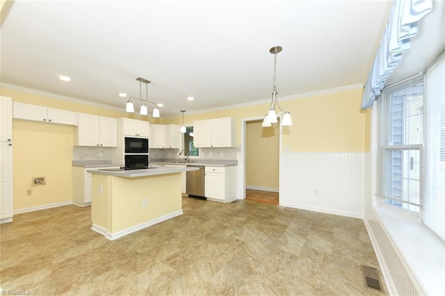 2377 Barber Rd, Elon, NC 27244 - kitchen with black appliances, a center island, ornamental molding, light countertops, and wainscoting