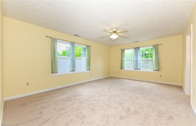 2377 Barber Rd, Elon, NC 27244 - spare room with plenty of natural light, a ceiling fan, a textured ceiling, light colored carpet, and baseboards