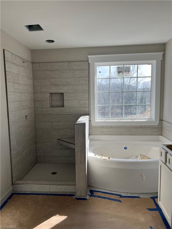 bathroom featuring tiled shower and a garden tub