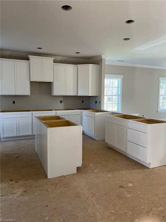 kitchen featuring recessed lighting, white cabinets, a center island, and crown molding