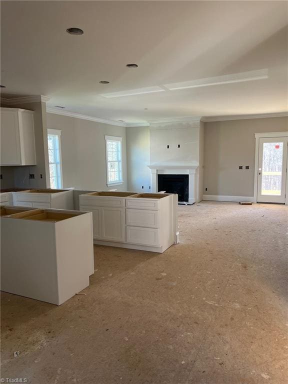 kitchen featuring white cabinets, a fireplace, and a healthy amount of sunlight