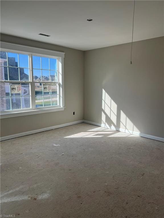 unfurnished room with visible vents and baseboards