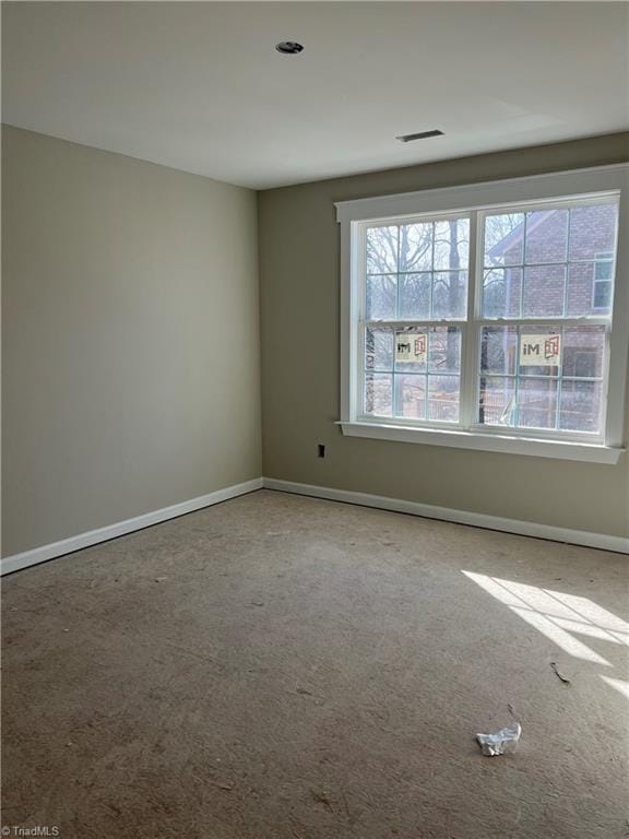 carpeted empty room with visible vents and baseboards