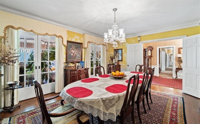 dining room with crown molding, an inviting chandelier, dark wood-type flooring, and french doors