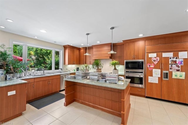 kitchen featuring built in appliances, light stone countertops, hanging light fixtures, and a kitchen island