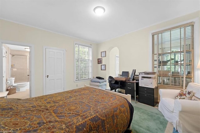 bedroom with carpet floors and connected bathroom