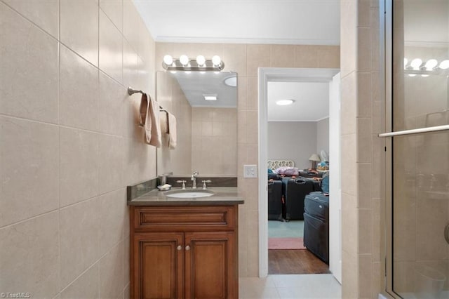 bathroom with vanity, tile walls, crown molding, and walk in shower