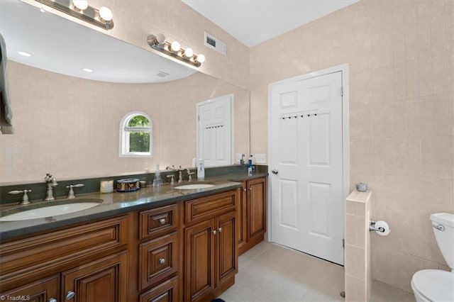 bathroom with tile walls, vanity, and toilet