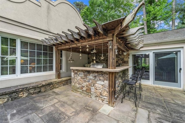 view of patio featuring a bar and a pergola