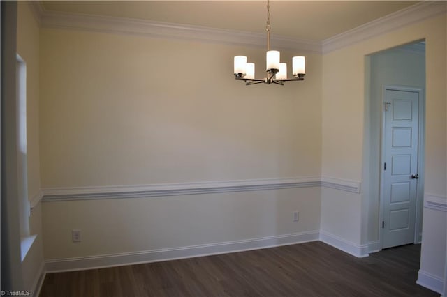 spare room featuring dark hardwood / wood-style flooring, an inviting chandelier, and ornamental molding