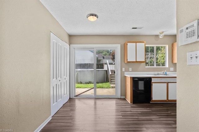 4103 Scotney Dr, Greensboro, NC 27407 - kitchen with black dishwasher, a textured wall, a textured ceiling, light countertops, and dark wood-style flooring