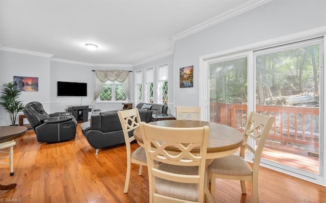 dining room with light wood-type flooring and crown molding