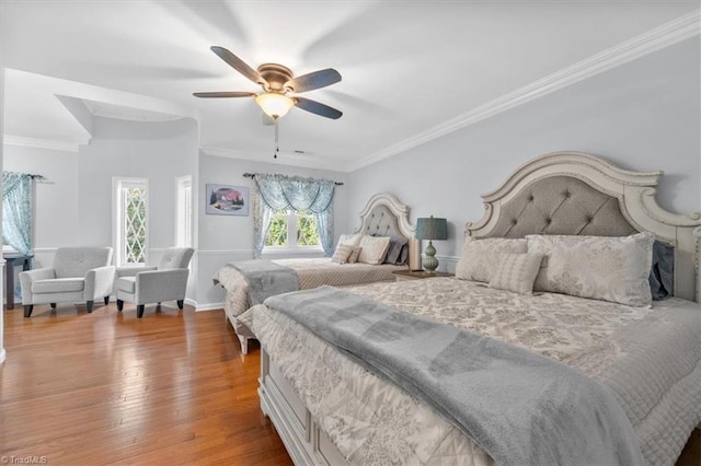 bedroom with ceiling fan, crown molding, baseboards, and hardwood / wood-style floors