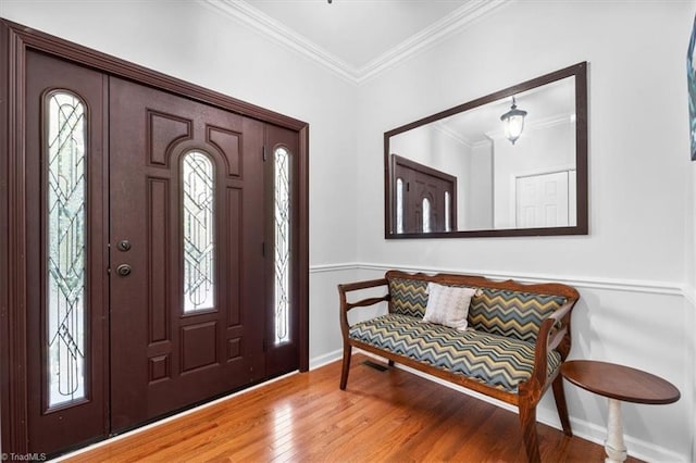 entrance foyer featuring baseboards, wood-type flooring, and ornamental molding