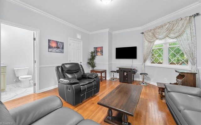 living area featuring light wood-style flooring, baseboards, and ornamental molding