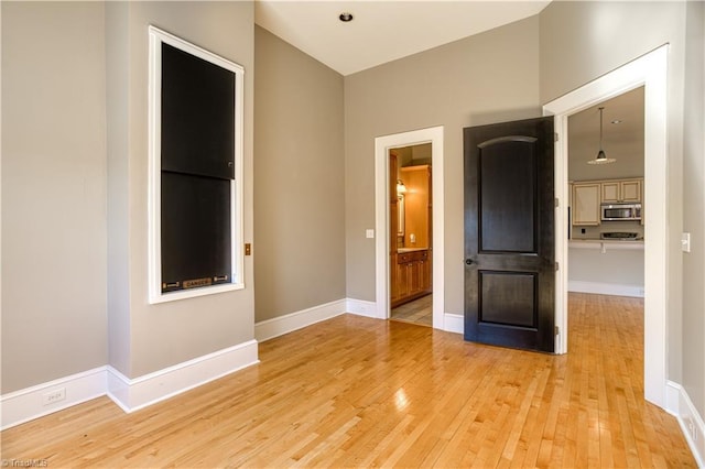 empty room featuring baseboards and light wood-style floors