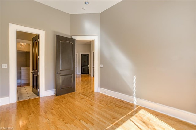 spare room featuring light wood-type flooring and baseboards