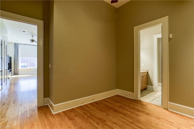 unfurnished room with light wood-type flooring, baseboards, and ceiling fan