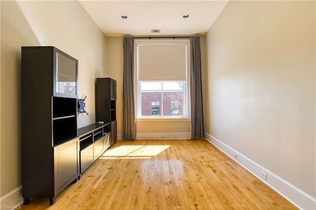 unfurnished living room with light wood-type flooring, visible vents, baseboards, and recessed lighting