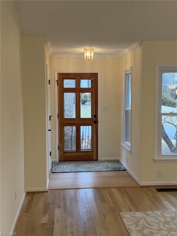 entryway featuring light hardwood / wood-style flooring and ornamental molding