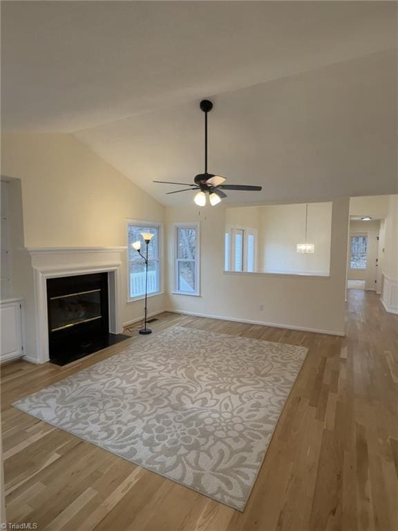 unfurnished living room with ceiling fan, wood-type flooring, and vaulted ceiling