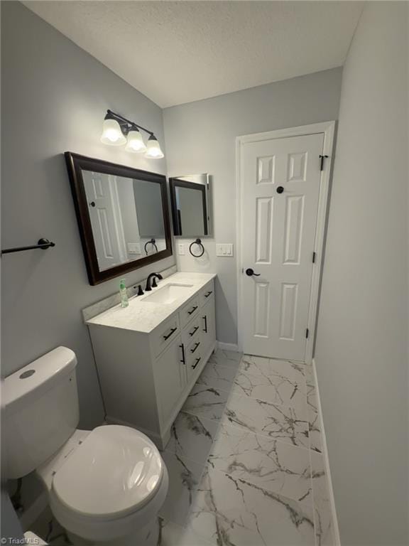 bathroom featuring vanity, a textured ceiling, and toilet