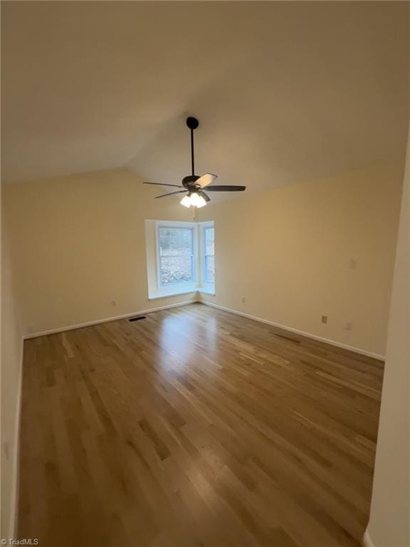 spare room featuring lofted ceiling, ceiling fan, and light hardwood / wood-style flooring