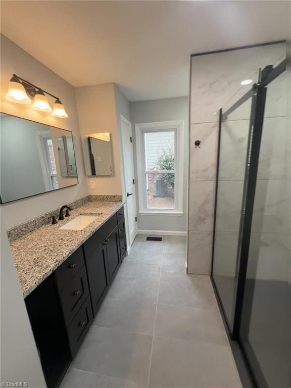 bathroom with vanity, tile patterned flooring, and walk in shower