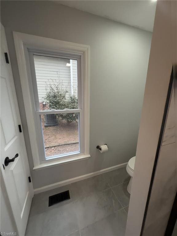 bathroom featuring toilet and tile patterned flooring