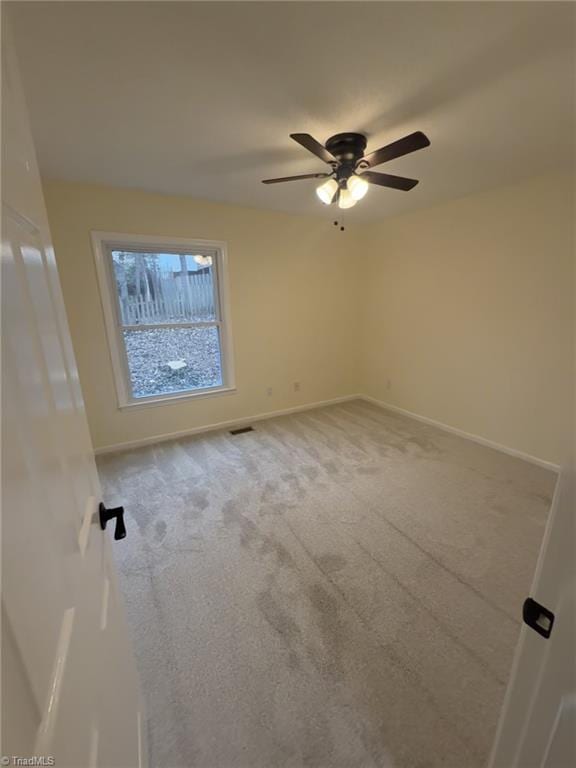 spare room with ceiling fan and carpet