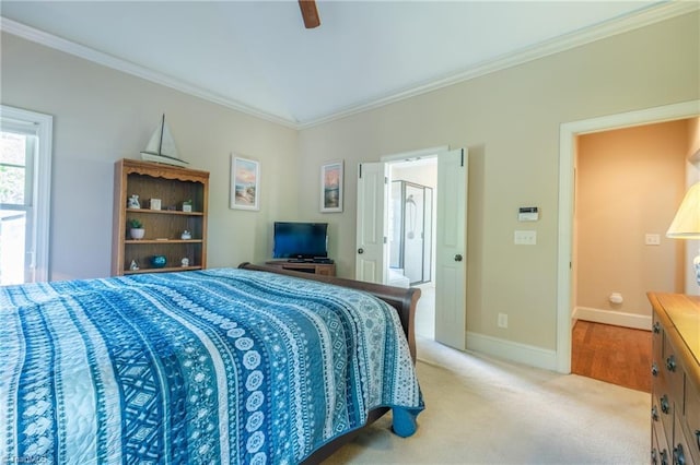 bedroom featuring light colored carpet, ornamental molding, baseboards, and a ceiling fan