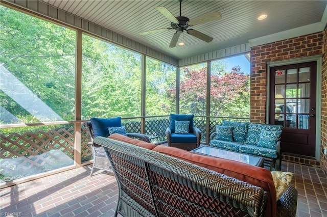 sunroom featuring an outdoor living space and a ceiling fan