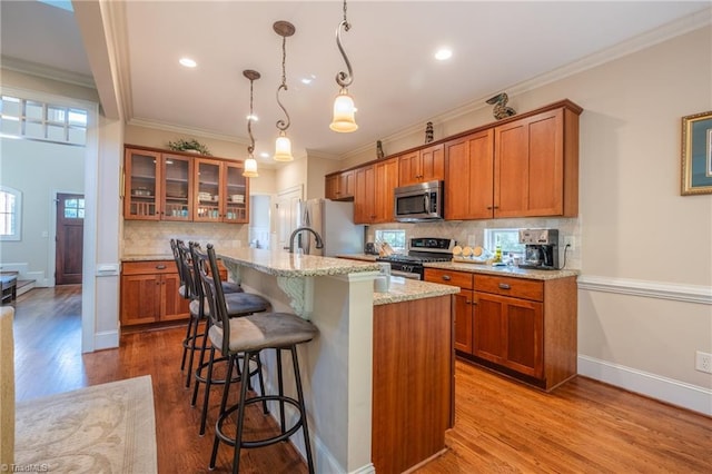 kitchen featuring brown cabinetry, a kitchen bar, and stainless steel appliances