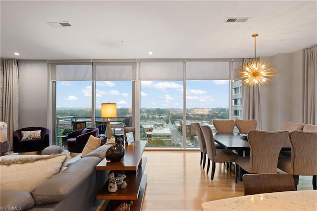 dining room featuring expansive windows, a chandelier, and light hardwood / wood-style floors