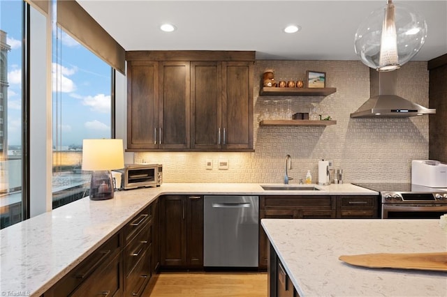 kitchen featuring sink, tasteful backsplash, decorative light fixtures, appliances with stainless steel finishes, and light stone countertops