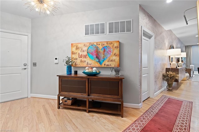 hall with an inviting chandelier and hardwood / wood-style floors