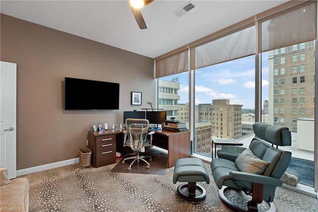 carpeted office space with ceiling fan and a wealth of natural light