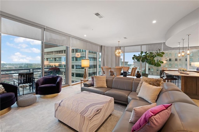 carpeted living room featuring a wall of windows and a notable chandelier