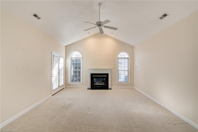 unfurnished living room with lofted ceiling, ceiling fan, light carpet, and a healthy amount of sunlight