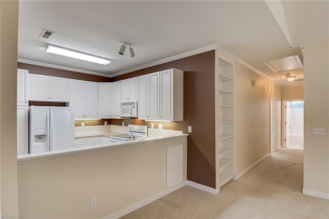 kitchen featuring light carpet, white cabinets, white appliances, and kitchen peninsula