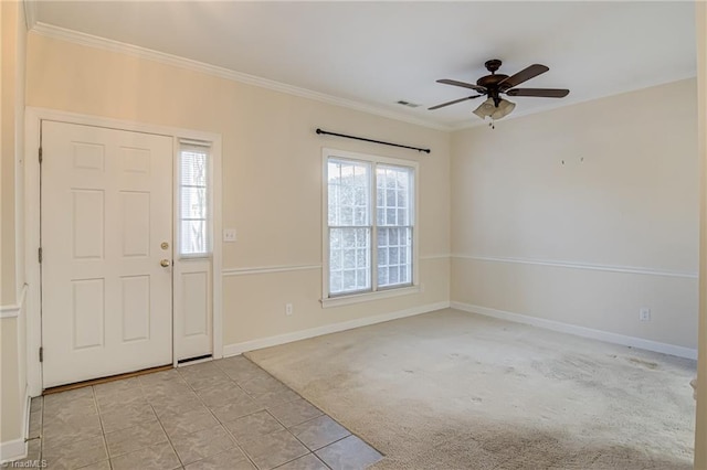 carpeted foyer entrance featuring ornamental molding and ceiling fan