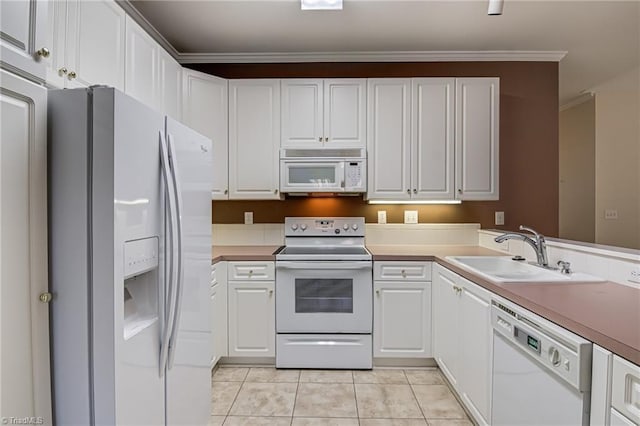 kitchen featuring sink, light tile patterned floors, ornamental molding, white appliances, and white cabinets