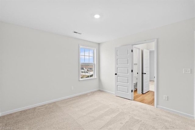 unfurnished room featuring light carpet