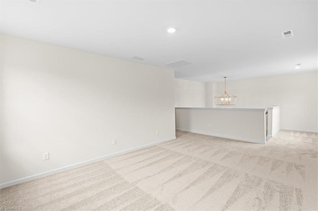 carpeted empty room with a chandelier