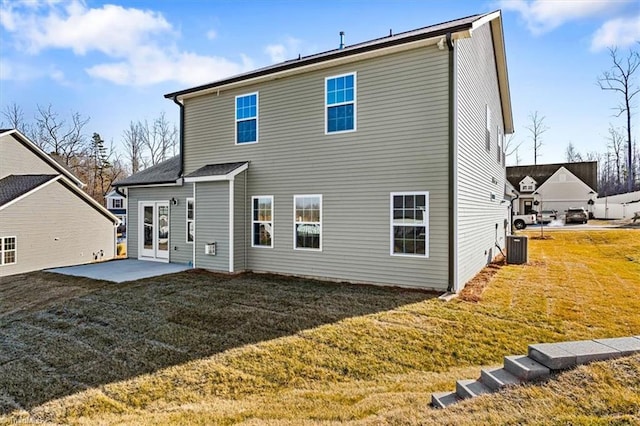 rear view of property featuring central AC, a patio, and a lawn