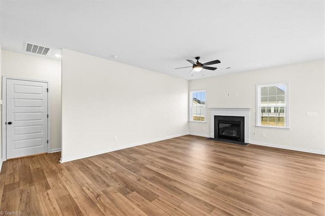 unfurnished living room featuring ceiling fan, a healthy amount of sunlight, and light wood-type flooring